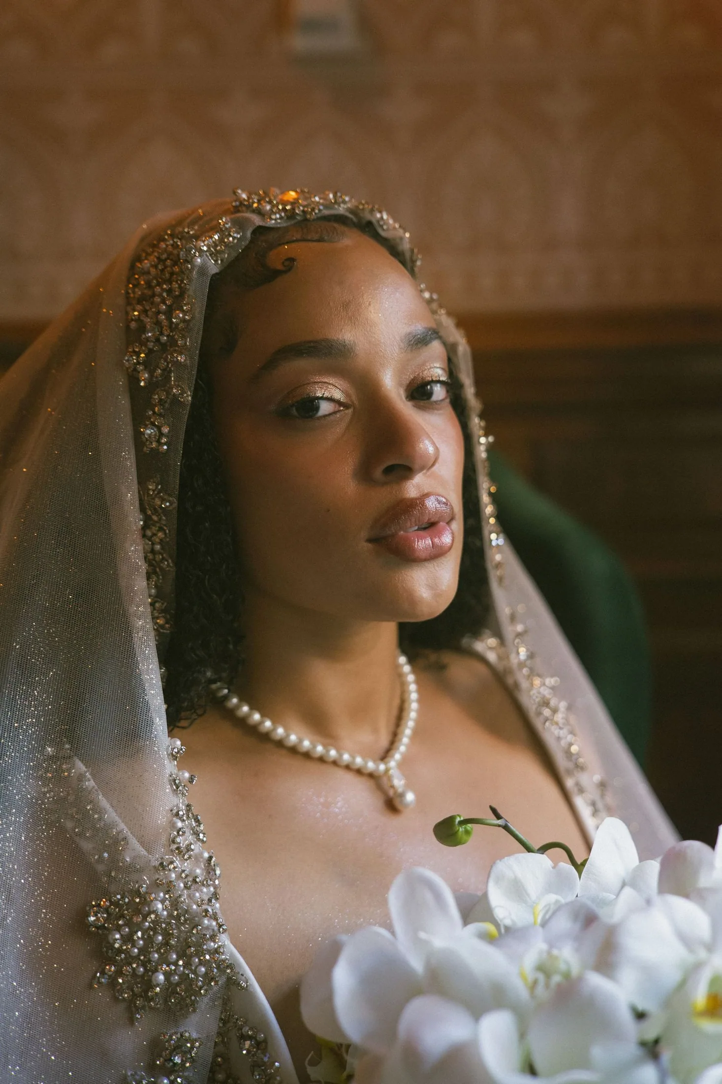 Close editorial portrait of a bride holding white flowers