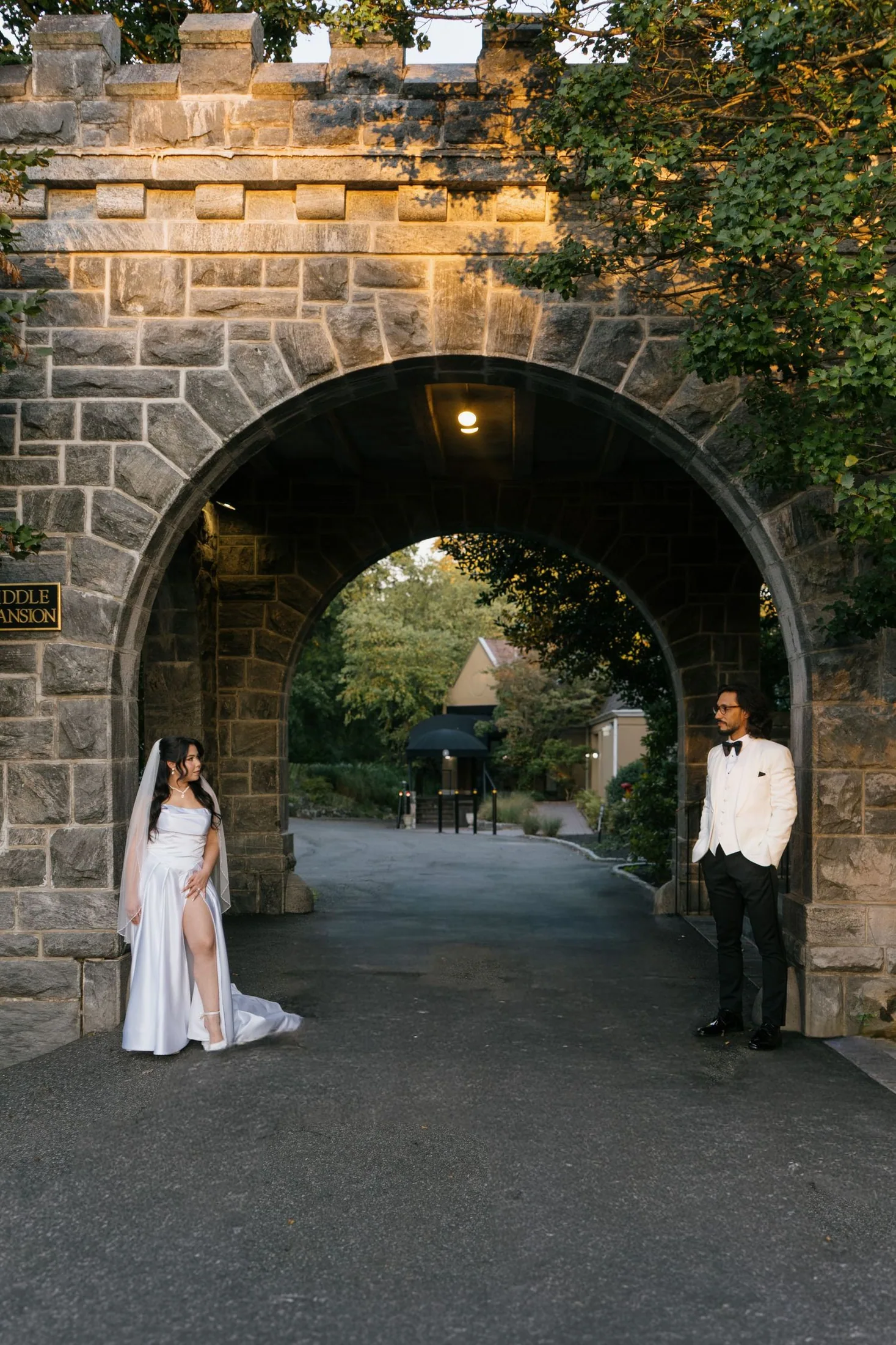Wedding portrait beneath a historic stone arch