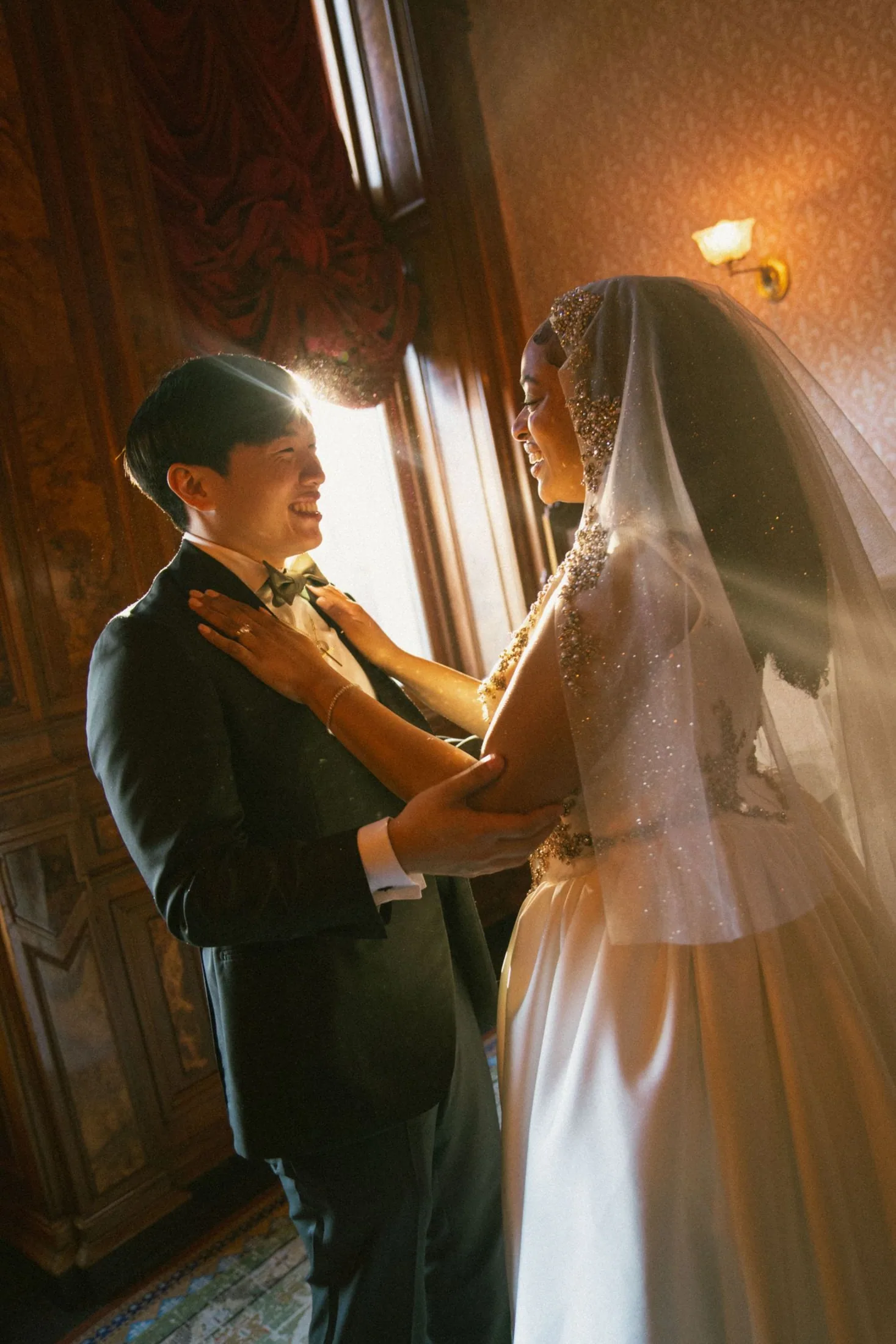 Wedding couple embracing in a beam of late-afternoon light